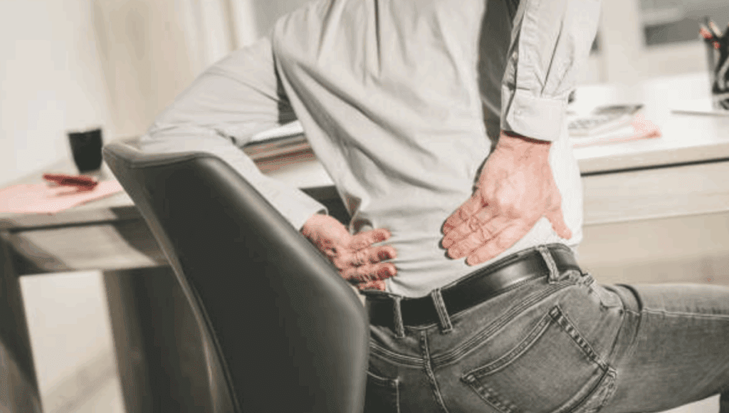 sittingwithlowbackpain Back pain, particularly lower back pain, is a common ailment that affects people of all ages. One of the leading contributors to this discomfort is poor posture while sitting for extended periods. Whether at work, during commutes, or relaxing at home, many of us spend hours seated, often in positions that strain our spines.